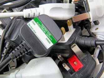 Electrical safety test label on a 3-pin plug, part of PAT testing for workplace and home electrical compliance.