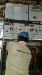 Electrical inspection by Corustar electrician working on an industrial panel during routine safety and maintenance checks.